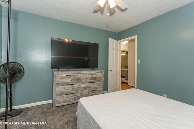 carpeted bedroom with ceiling fan and a textured ceiling