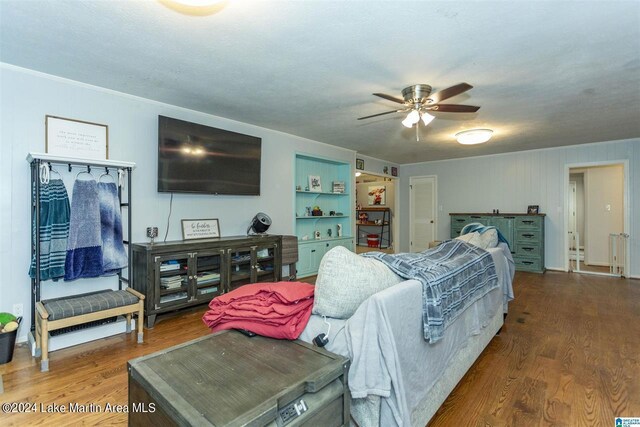 living room featuring wood-type flooring, ceiling fan, and crown molding