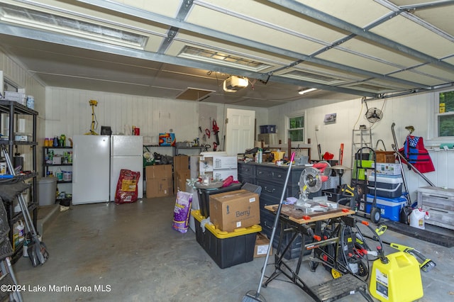 garage featuring white fridge and a garage door opener