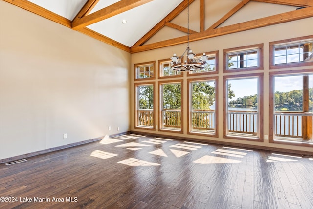 unfurnished room featuring visible vents, dark wood-type flooring, baseboards, a notable chandelier, and high vaulted ceiling