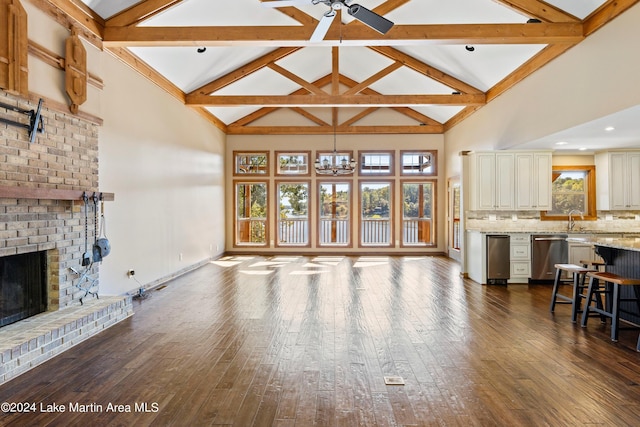 living room featuring a notable chandelier, a fireplace, high vaulted ceiling, and dark wood-style flooring