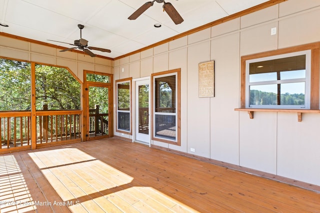 unfurnished sunroom featuring a ceiling fan and a wealth of natural light