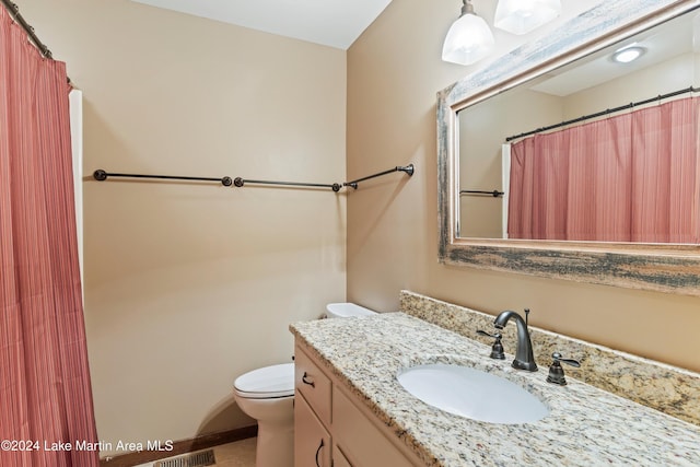 full bath featuring vanity, a shower with shower curtain, and toilet