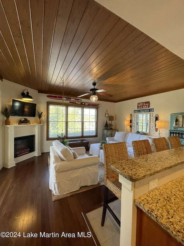 bedroom with ceiling fan, dark hardwood / wood-style flooring, and wooden ceiling