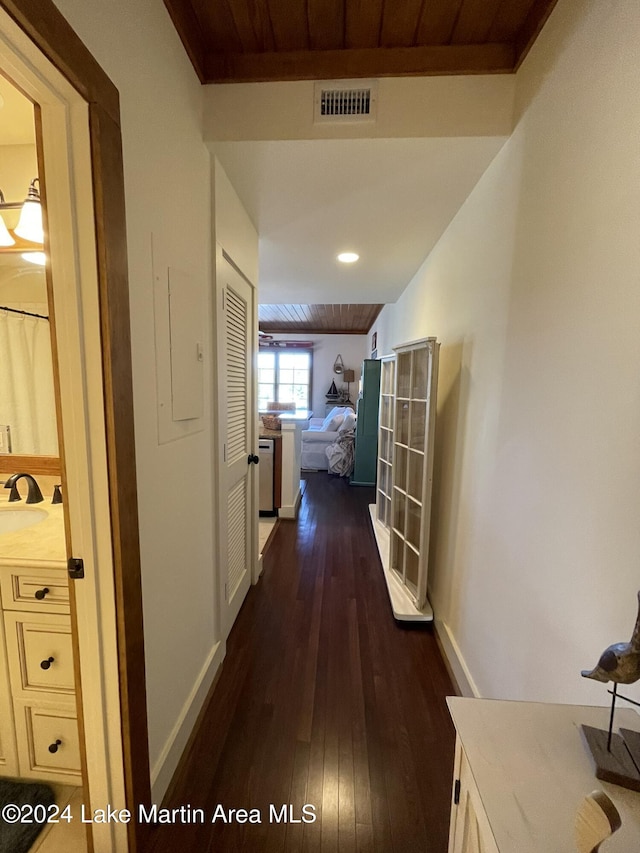 hall with electric panel, wooden ceiling, dark wood-type flooring, and sink