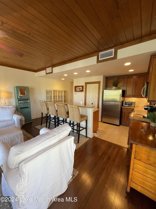 living room with light hardwood / wood-style flooring and wooden ceiling