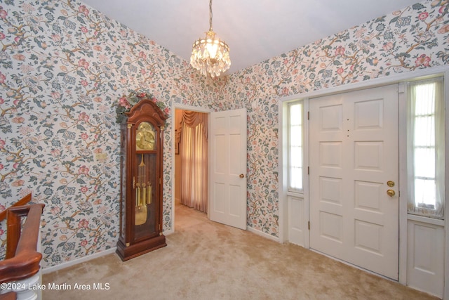 carpeted entrance foyer with a chandelier and a healthy amount of sunlight