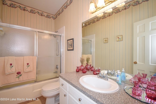 full bathroom with shower / bath combination with glass door, vanity, and toilet