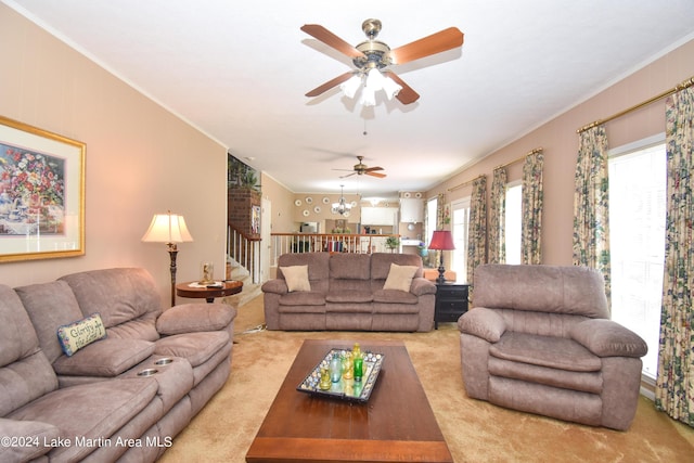 living room featuring light carpet, ceiling fan with notable chandelier, and crown molding