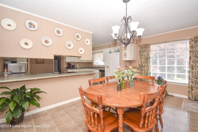 dining room with a chandelier, crown molding, and sink