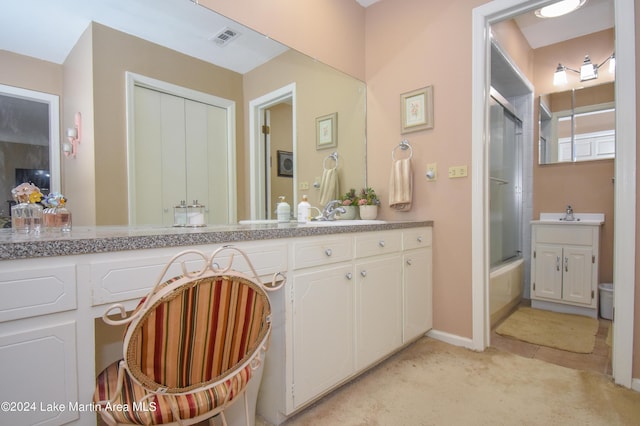 bathroom featuring vanity and bath / shower combo with glass door