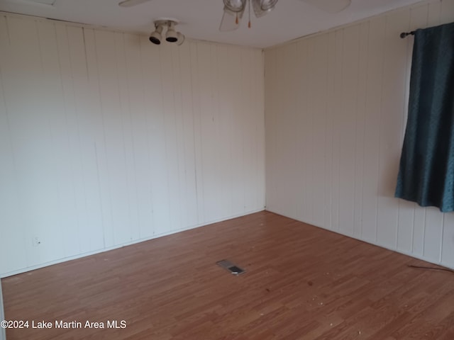 empty room with wood walls and wood-type flooring