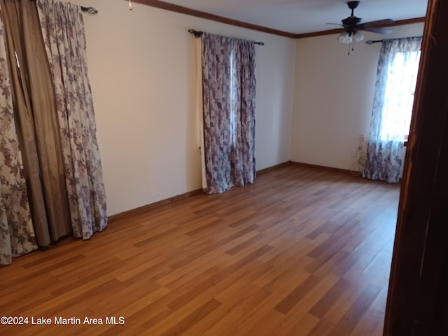 empty room featuring ceiling fan, ornamental molding, and light wood-type flooring