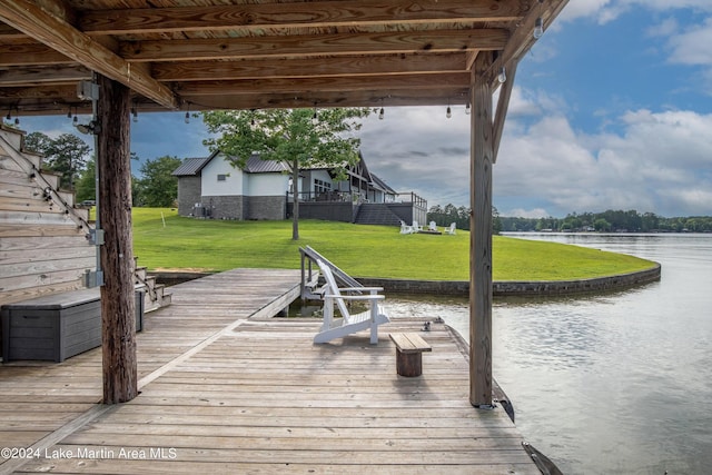 dock area with a lawn and a water view