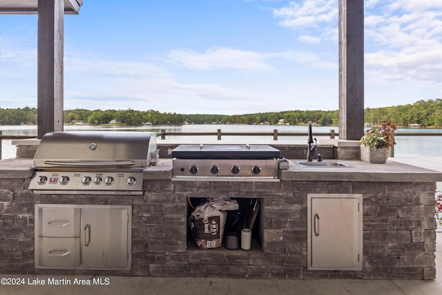 view of patio featuring sink, a water view, grilling area, and exterior kitchen