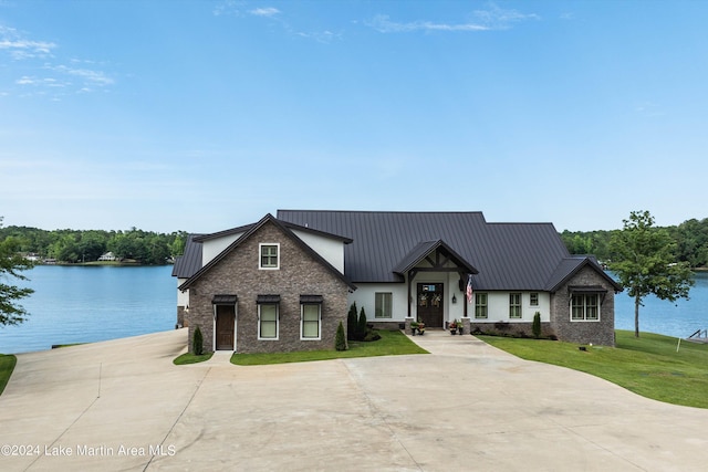 view of front of house with a water view and a front lawn