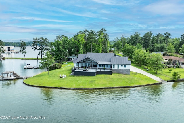 back of property featuring a water view and a yard