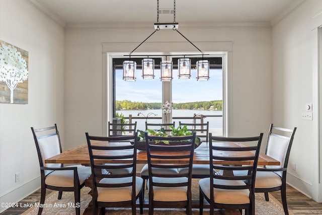 dining space with wood-type flooring, a water view, and crown molding