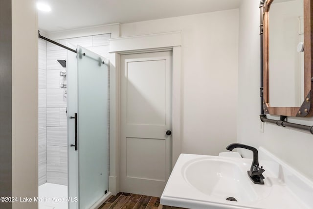 bathroom featuring hardwood / wood-style floors, vanity, and a shower with shower door