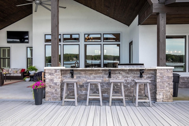 deck featuring ceiling fan and exterior bar