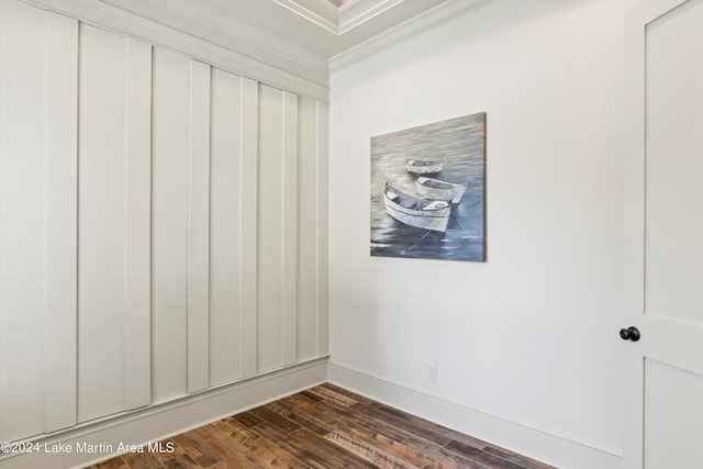 empty room featuring crown molding and dark wood-type flooring