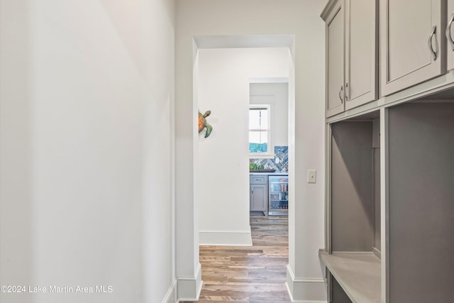 mudroom with wood-type flooring and beverage cooler