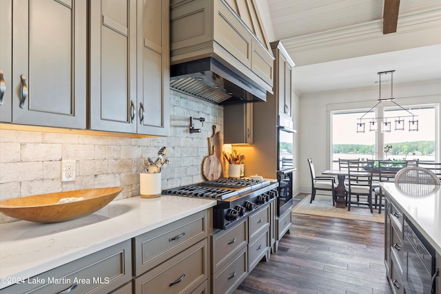 kitchen featuring premium range hood, hanging light fixtures, tasteful backsplash, dark hardwood / wood-style flooring, and stainless steel gas cooktop