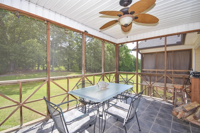 sunroom / solarium featuring outdoor dining area and ceiling fan