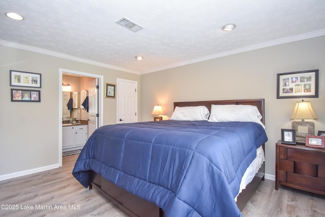 bedroom with visible vents, light wood finished floors, crown molding, and baseboards