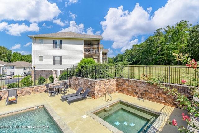 view of swimming pool featuring a fenced backyard, a fenced in pool, an in ground hot tub, and a patio area
