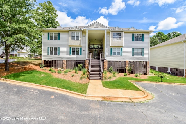 view of front of house with stairway and a front yard