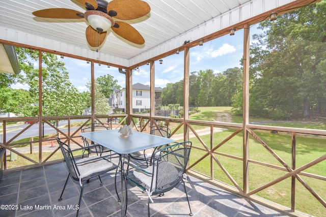sunroom / solarium featuring ceiling fan and outdoor dining space