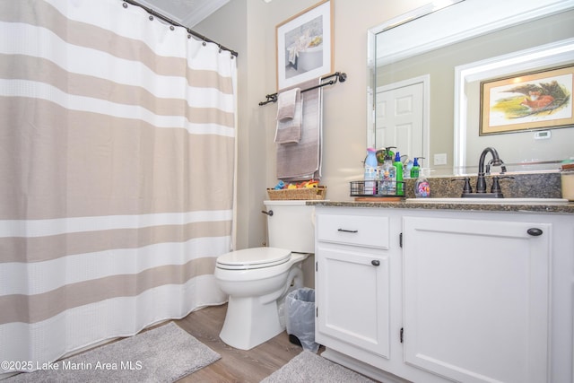 bathroom with crown molding, vanity, toilet, and wood finished floors