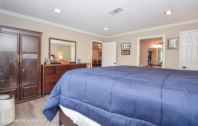 bedroom with visible vents, recessed lighting, crown molding, and wood finished floors