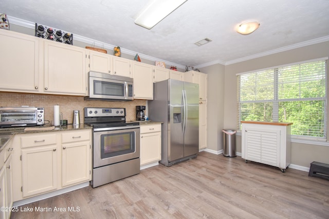 kitchen with visible vents, appliances with stainless steel finishes, a toaster, and tasteful backsplash