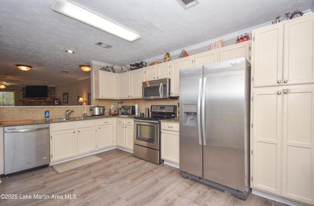 kitchen featuring a sink, decorative backsplash, stainless steel appliances, and visible vents