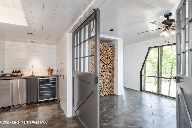 bar featuring wine cooler, fridge, wood ceiling, and wooden walls