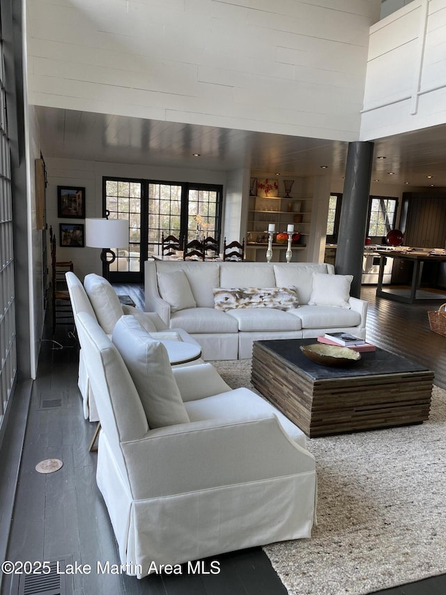 living room featuring plenty of natural light, dark hardwood / wood-style floors, and a high ceiling