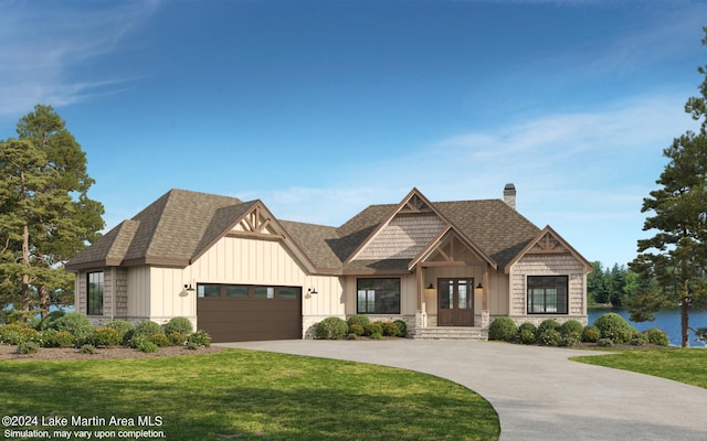 view of front of property with a water view, french doors, a front lawn, and a garage