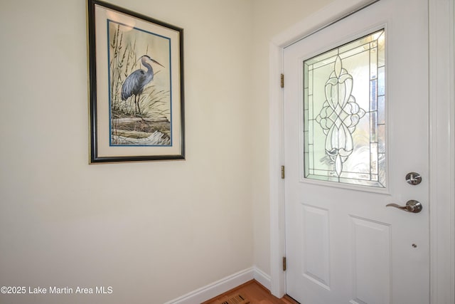 foyer with wood finished floors and baseboards