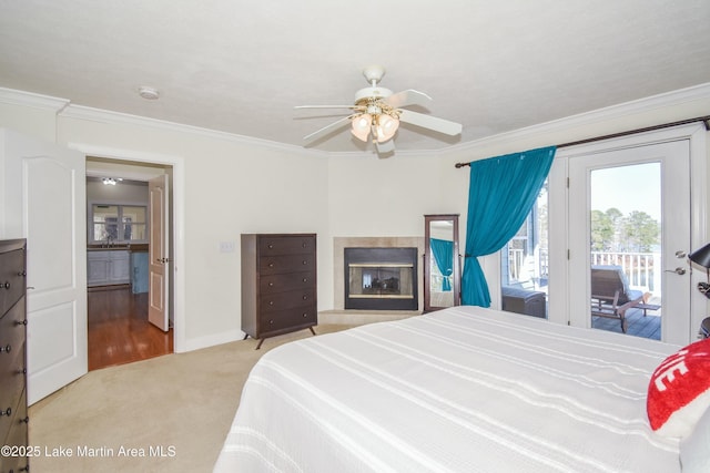 carpeted bedroom featuring access to outside, baseboards, a multi sided fireplace, and ornamental molding