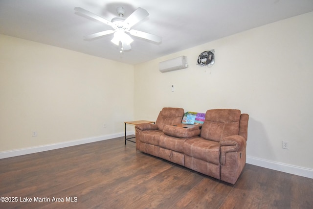 sitting room with baseboards, an AC wall unit, ceiling fan, and wood finished floors