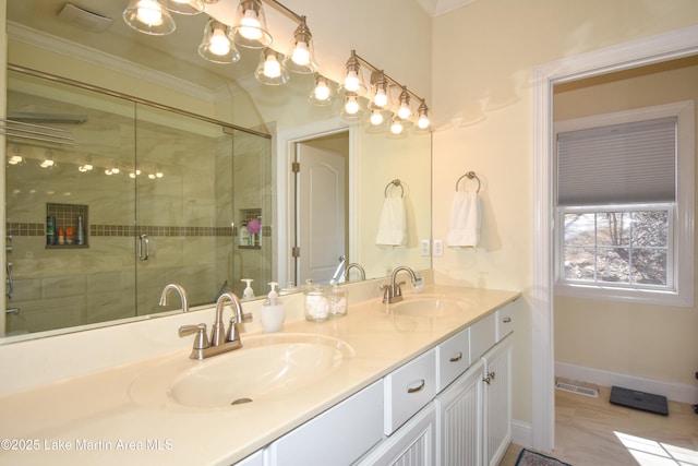 bathroom featuring double vanity, visible vents, crown molding, and a sink