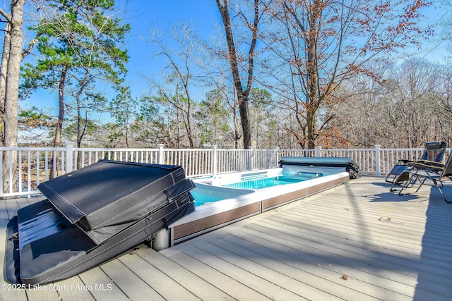 wooden deck with a covered hot tub