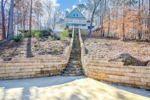 rear view of house featuring a porch and stairs