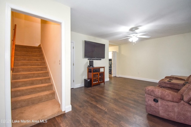 living area with a ceiling fan, stairway, wood finished floors, and baseboards