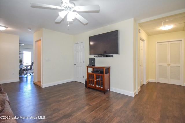 living area with baseboards, wood finished floors, and a ceiling fan