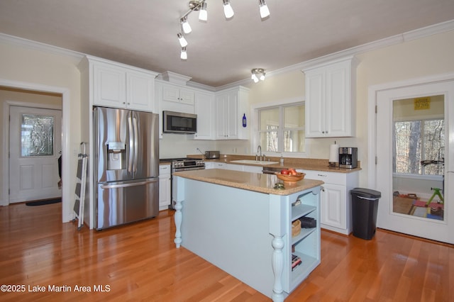 kitchen featuring light wood-style flooring, a sink, open shelves, white cabinetry, and stainless steel appliances