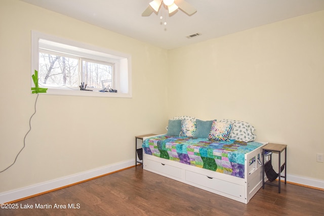 bedroom featuring ceiling fan, wood finished floors, visible vents, and baseboards