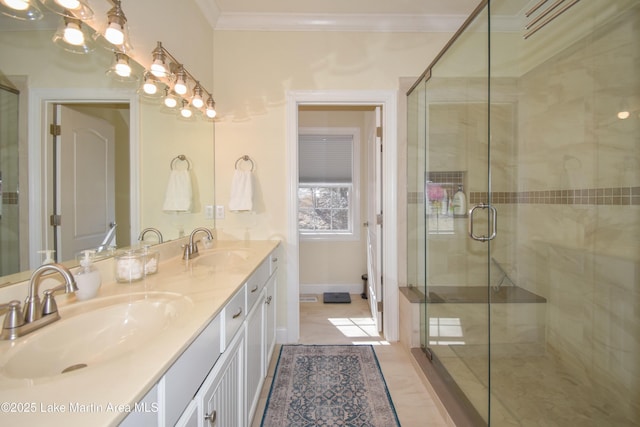 full bath with double vanity, a shower stall, crown molding, and a sink